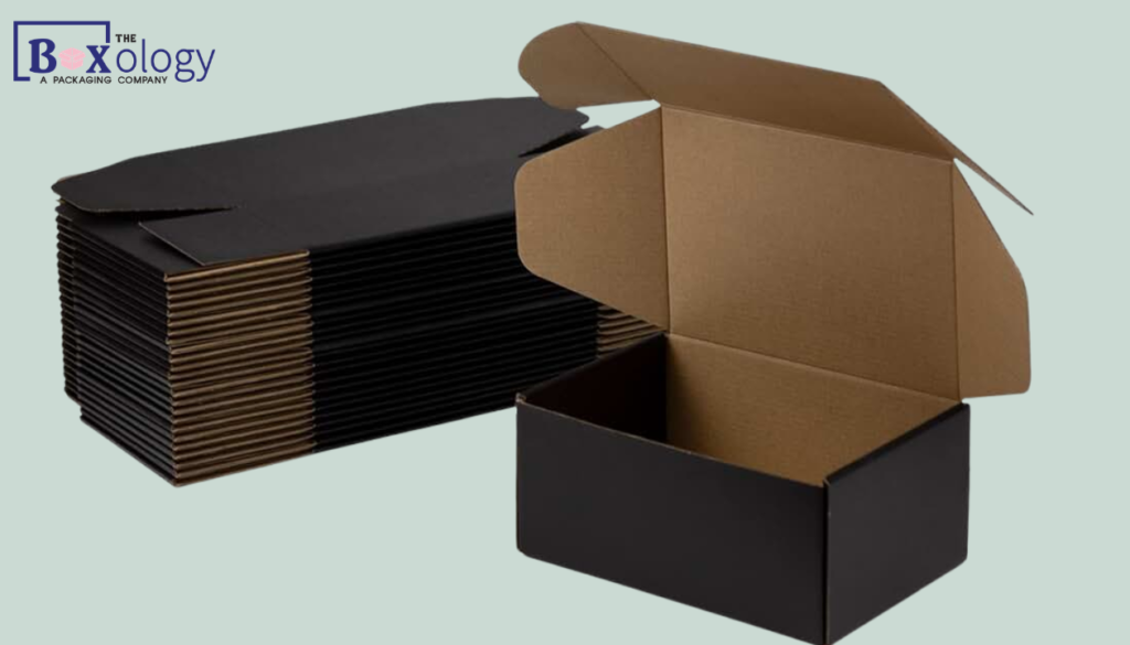 4 11 - Mailer Boxes Packaging Solution Wholesale black mailer boxes stacked in a bulk packaging warehouse.