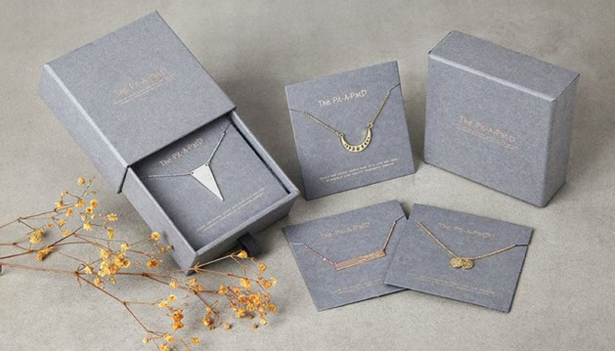 Close up view of custom magnetic rigid boxes USA manufacturing details showing thick greyboard core and deep blue premium textured paper wrapper with gold foil stamped logo.